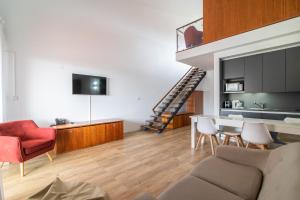a living room with a couch and a red chair at ANC Resort in Caloura