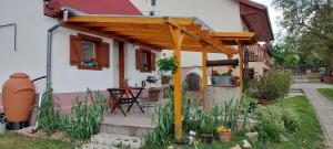 a wooden pergola on the side of a house at Small House Apartment in Kerepes