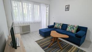 uma sala de estar com um sofá azul e uma televisão em Main Square Apartment - Skopje em Skopje