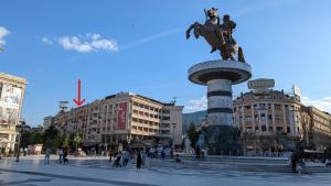 uma estátua no meio de uma cidade com edifícios em Main Square Apartment - Skopje em Skopje