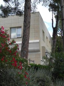 a building with a tree and flowers in front of it at Ospitaci Casa Vacanze Trevi in Perugia