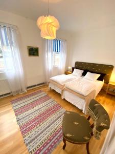 1 dormitorio con 1 cama, 2 sillas y 1 alfombra en Blankaholm nära marinan, en Blankaholm