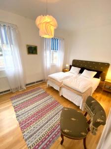 a bedroom with a bed and two chairs and a rug at Blankaholm 1 nära marinan in Blankaholm