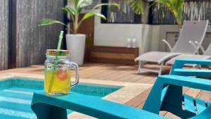 Una bebida en un frasco de vidrio sobre una mesa junto a una piscina. en Tala Lodge Bonaire, en Kralendijk
