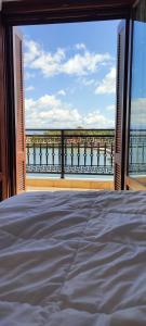 a bedroom with a view of the ocean from a balcony at l' atoll d' Helene in Gythio