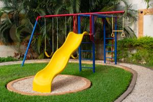 a playground with a yellow slide in the grass at Hotel Palacio Maya in Mérida