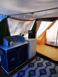 a tent with a stove and a bed in it at Volledig ingerichte tent op natuurcamping in Gräsmark