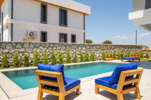アラカティにあるLovely Villa with Private Pool in Alacati Cesmeのスイミングプールと椅子2脚付きのヴィラです。