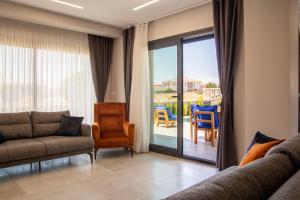 ein Wohnzimmer mit einem Sofa und einer Glasschiebetür in der Unterkunft Lovely Villa with Private Pool in Alacati Cesme in Alacati