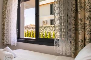 a bedroom with a window with a view of a building at Lovely Villa with Private Pool in Alacati Cesme in Alacati