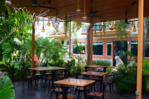 un patio extérieur avec des tables, des chaises et des plantes dans l'établissement Hotel Palacio Maya, à Mérida