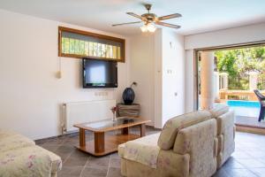 een woonkamer met een bank, een tafel en een tv bij Enchanting Villa with Backyard in Cesme near Beach in Alacati