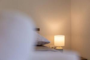 ein Schlafzimmer mit einem Bett mit einer Lampe in der Unterkunft Teodora holiday house seafront in Kaštela