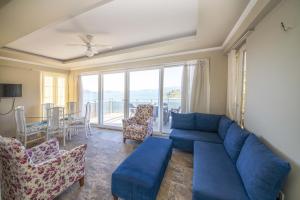 ein Wohnzimmer mit einem blauen Sofa und einem Tisch in der Unterkunft Lovely Villa with Sea View, Balcony and Terrace in Milas, Bodrum in Bogazici