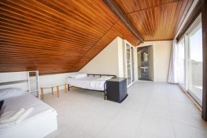 Habitación con 2 camas y techo de madera. en Lovely Villa with Sea View, Balcony and Terrace in Milas, Bodrum, en Bogazici