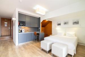 um quarto com uma cama branca e uma cozinha em ANC Resort em Caloura