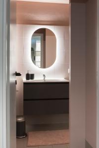y baño con lavabo y espejo. en Xenia Apartments - Moderno appartamento in Fondazione Prada, en Milán
