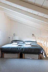 Cama grande en habitación con techo en Xenia Apartments - Moderno appartamento in Fondazione Prada, en Milán