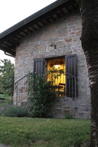 a stone house with a window with a table in it at Casale Don Giovanni in Prepotto