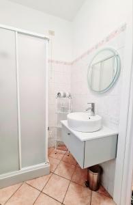 Baño blanco con lavabo y espejo en Appartamento San Giorgio, en Lovere