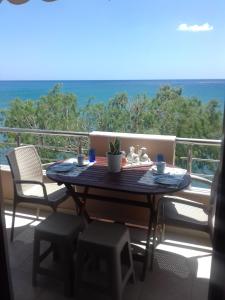 una mesa en un balcón con vistas al océano en Maria's Apartment, en Tsoutsouros