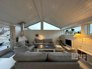 uma sala de estar com um sofá e uma lareira em Fantastic Sea Cottage on Justøya Island, Lillesand em Lillesand