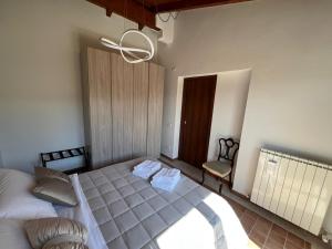 a bedroom with a bed and a chair and a chandelier at B&B La cas' d'Alfonz' in Sulmona