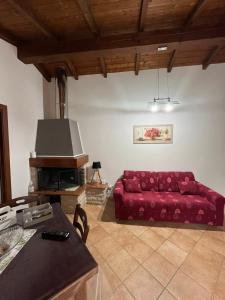 un soggiorno con divano rosso e tavolo di B&B La cas' d'Alfonz' a Sulmona