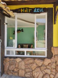 una ventana en un edificio con una pared de piedra en Pousada Mar Azul, en Abraão