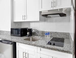 a kitchen counter with a sink and a microwave at R Hotel Kingston in Kingston