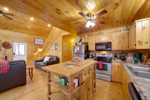 a kitchen and living room in a log cabin at Blue Ridge Mountain Cabin with Views, 2 Mi to Dtwn! in Murphy