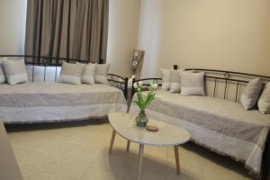 Sala de estar con 2 camas y mesa en Myrina View 2, en Mirina