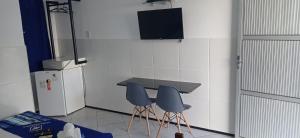 a kitchen with two blue chairs and a table at Hotel Arco-Íris in Itapipoca