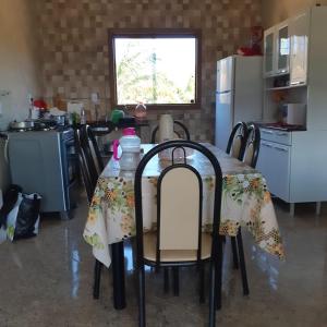 een keuken met een tafel met een tafelkleed erop bij Pouso dos Sonhos Suítes Lapinha da Serra in Santana do Riacho