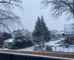 a snow covered street with trees in a town at Ferienwohnung mit Balkon - 3 Zimmer in Wedemark