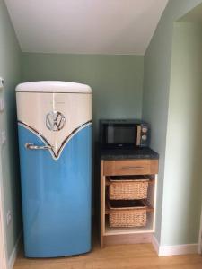 a blue refrigerator in a room with a microwave at The Old Coastguard Station, Lochinver in Lochinver