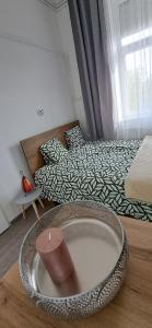 a room with a bed and a bowl on the floor at Napraforgó apartman in Szeged