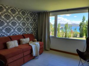 sala de estar con sofá y ventana grande en GreJa Lodge, Limay, Patagonia en Dina Huapi