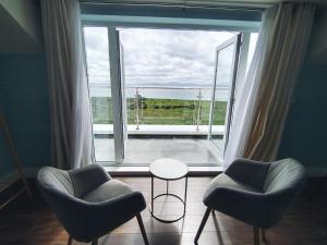 two chairs and a table in front of a large window at Vista Mara in Donegal