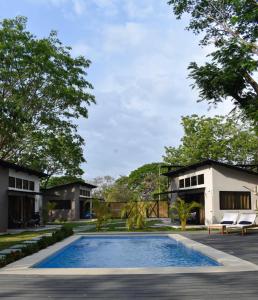 a swimming pool in front of a house at Blue Window Boutique Villas Hotel in Playa Junquillal