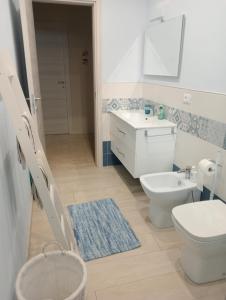 een badkamer met een wit toilet en een wastafel bij La Casa di Giò in Asti