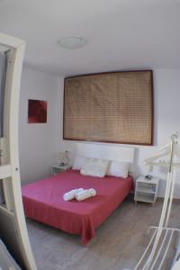 チクラナ・デ・ラ・フロンテーラにあるSancti Petri Houseのベッドルーム1室(赤いベッド1台、タオル2枚付)