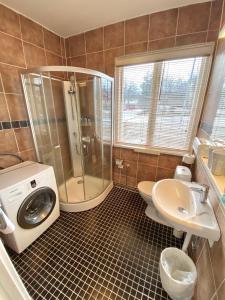 a bathroom with a shower and a washing machine at Blankaholm 1 nära marinan in Blankaholm