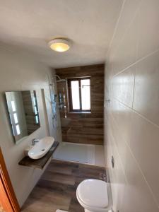 a bathroom with a white toilet and a sink at Villa Serenita in Xagħra