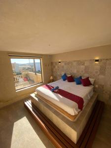 Cama grande en habitación con ventana grande en Villa Serenita, en Xagħra