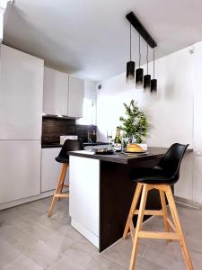 a kitchen with a black and white counter and stools at Palais 5min Luxury&Cinema Studio in Cannes +54 photos