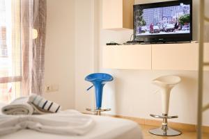 una camera con due sgabelli e una TV a muro di COASTAL RETREAT - Beach Apartment Vlore a Vlorë