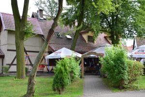 budynek ze stołami i parasolami przed nim w obiekcie Chata Mazurska Marek Pyśk w mieście Mrągowo