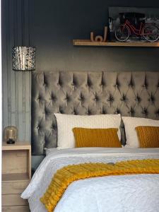 a bedroom with a large bed with yellow pillows at LuxuryAirportLodge near OR TAMBO in Kempton Park