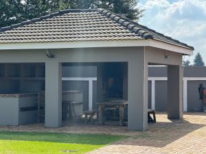 a pavilion with a picnic table in a yard at LuxuryAirportLodge near OR TAMBO in Kempton Park